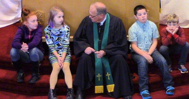 Pastor Mike sharing a children's moment on the chancel steps