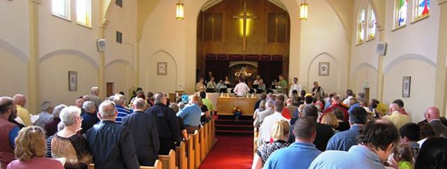 The congregation gathered around the communion table during Sunday worship